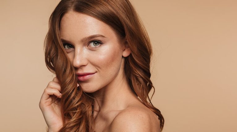 beauty-portrait-mystery-smiling-ginger-woman-with-long-hair-posing-sideways-looking-min